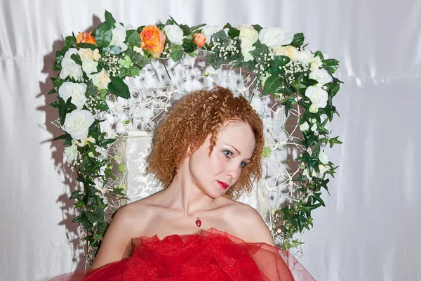 Girl in red posing on chair flower — Stock Photo, Image