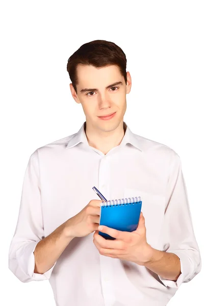 Young man writes in blue notebook — Stock Photo, Image