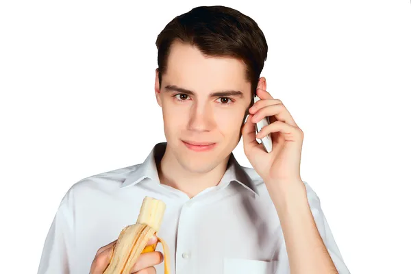 Young man eating banana and talking on the phone closeup — Stock Photo, Image