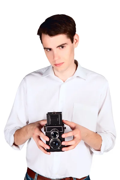 Joven con cámara retro en la mano en una camisa blanca aislada sobre fondo blanco —  Fotos de Stock