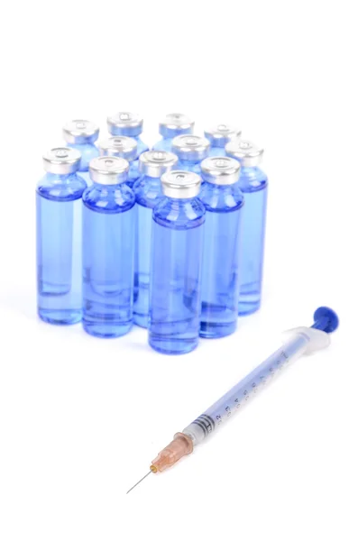 Injekční stříkačky a lahvičky na bílém pozadí — Stock fotografie