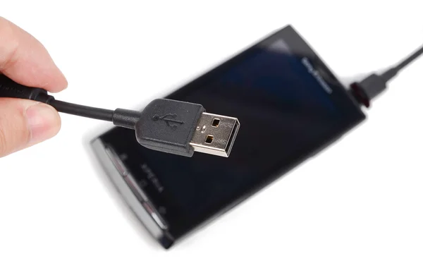 Teléfono móvil y cable USB sobre fondo blanco —  Fotos de Stock