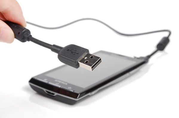 Telefone celular e cabo USB no fundo branco — Fotografia de Stock