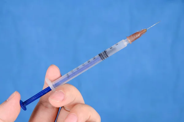 Syringe on blue background — Stock Photo, Image