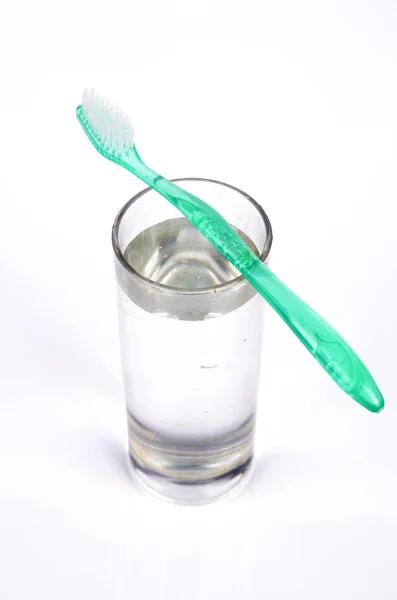 Зубная щетка и стакан воды — стоковое фото