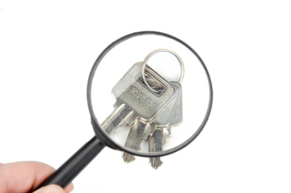 Vergrootglas en sleutels — Stockfoto