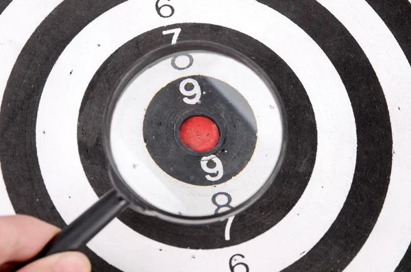 Magnifier and dartboard — Stock Photo, Image