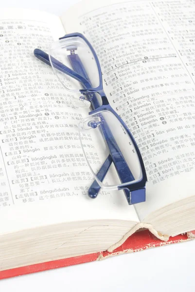 Glazen en woordenboek — Stockfoto