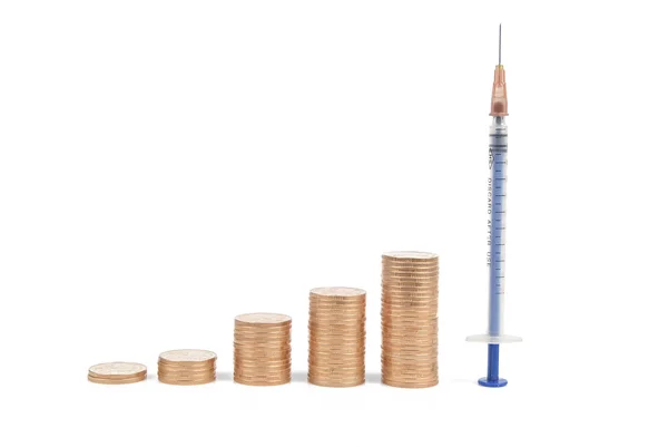 Coins and syringe — Stock Photo, Image