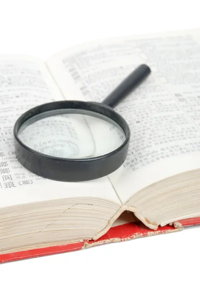 Magnifier and dictionary — Stock Photo, Image