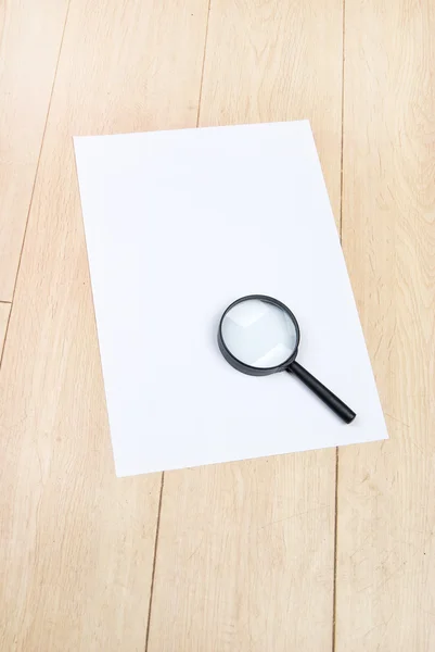 A4 paper and magnifier — Stock Photo, Image