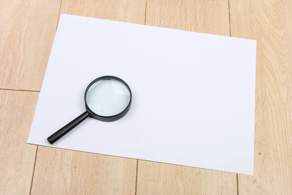 A4 paper and magnifier — Stock Photo, Image