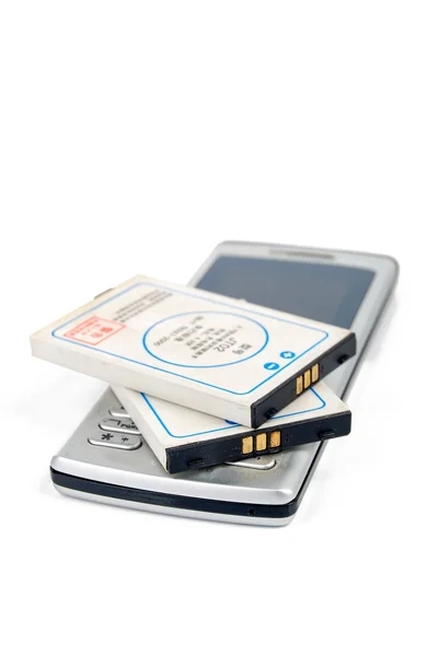 Batterie et téléphone sur fond blanc — Photo