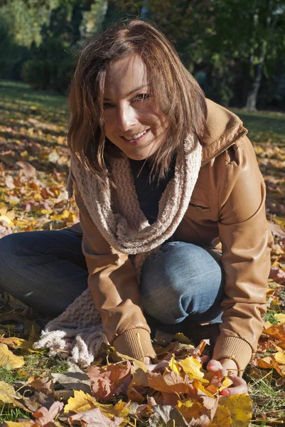 Женщина с опавшими живыми листьями — стоковое фото