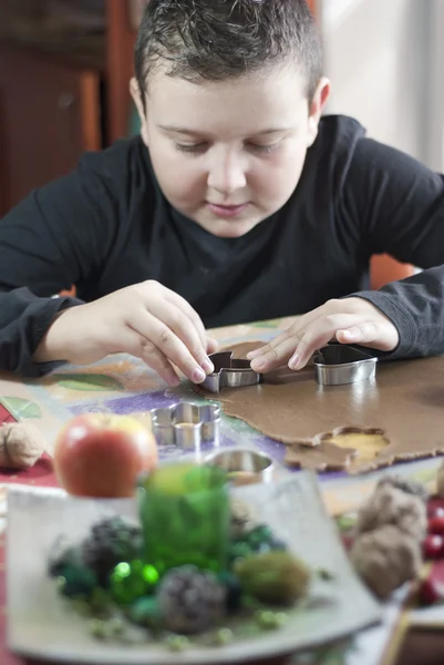 Boy will focus on cutting gingerbread dough — Stock Photo, Image