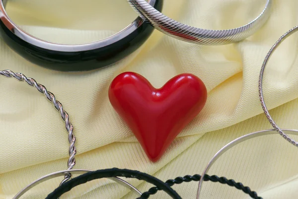 Red heart with various bracelets — Stock Photo, Image