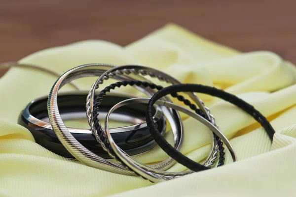 Várias pulseiras em um tecido amarelo — Fotografia de Stock