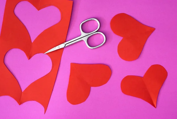 Красные сердца вырезаны металлическими ножницами — стоковое фото