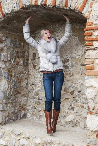 Beautiful blond woman posing in brick niche — Stock Photo, Image