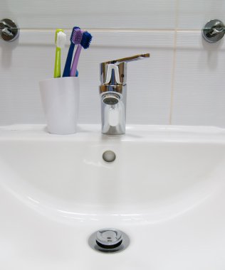 White sink and toothbrushes clipart