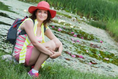 şapka ve nilüferler gölde bir genç kadın