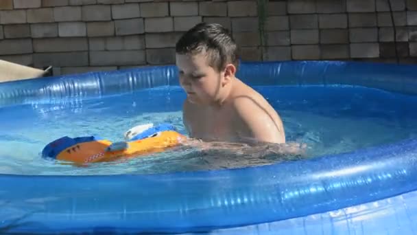 Junge mit dem Spielzeugschiff im Pool — Stockvideo