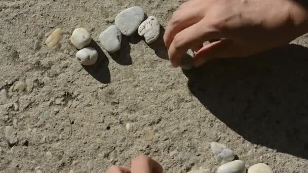 Human hands makes little heart of stones — Stock Video