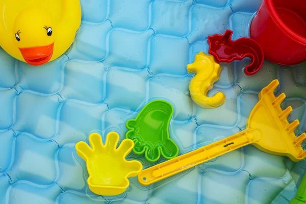 Brinquedos de bebê à beira da piscina — Fotografia de Stock