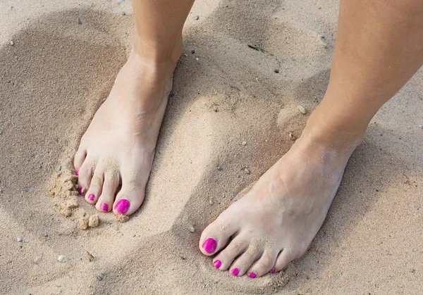女赤裸的双脚在沙子里 图库图片