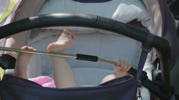 Kinderfüße im Kinderwagen — Stockvideo