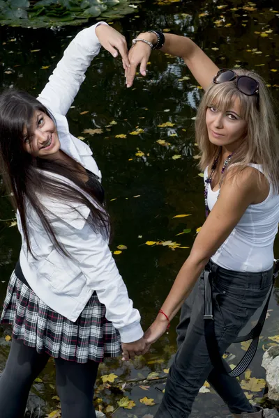Due donne allegre che fanno forma di cuore con le mani — Foto Stock