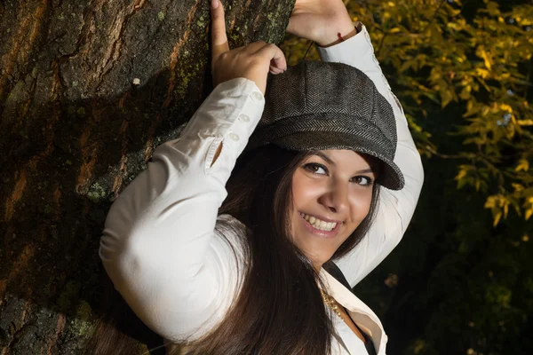 Chica feliz posando cerca del árbol —  Fotos de Stock