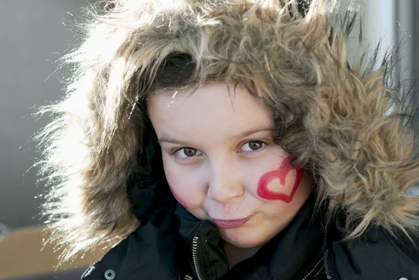 Ler kaukasiska pojke med målade hjärta i ansiktet — Stockfoto