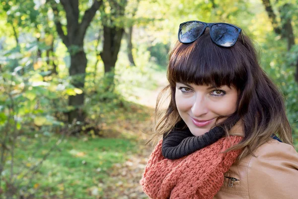 Mooie brunette poseren in herfst park — Stockfoto