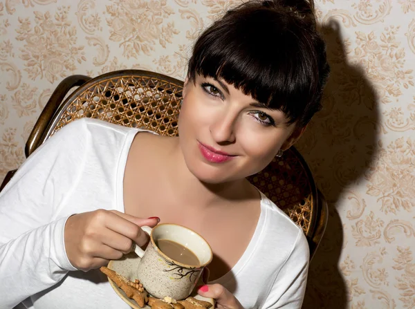 Mooie jonge Kaukasische vrouw houdt een kopje cappuccino — Stockfoto