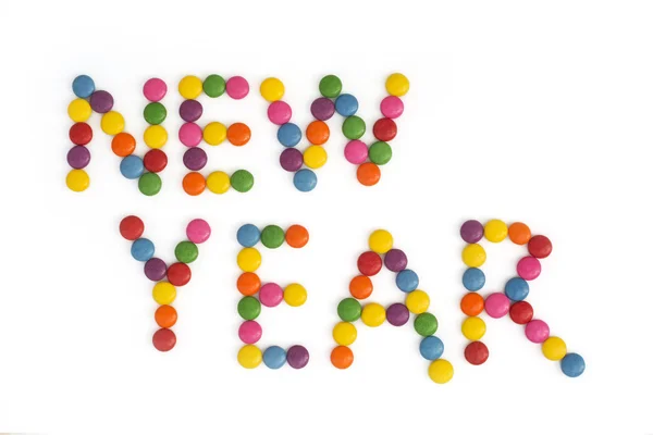 The title NEW YEAR written of the colored smarties — Stock Photo, Image