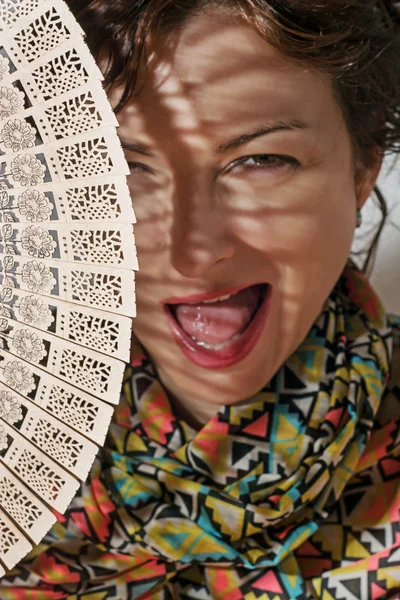 Jeune femme caucasienne dans l'ombre avec un ventilateur traditionnel — Photo