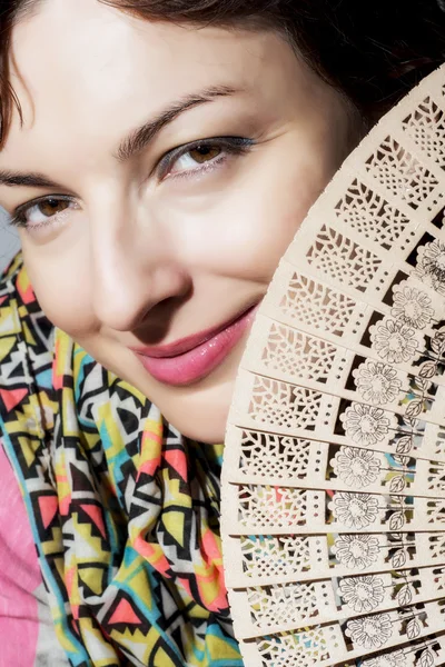 Mooie lachende vrouw met een ventilator — Stockfoto