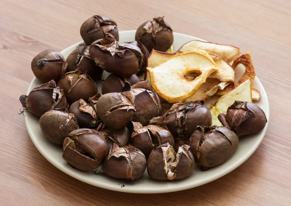 Tasty roasted chestnuts and dried sliced apples — Stock Photo, Image