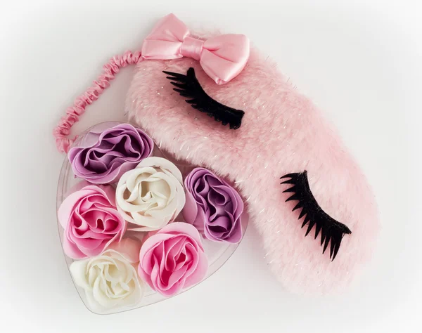 Roze slapen masker en kleine hart gemaakt van stof bloemen — Stockfoto