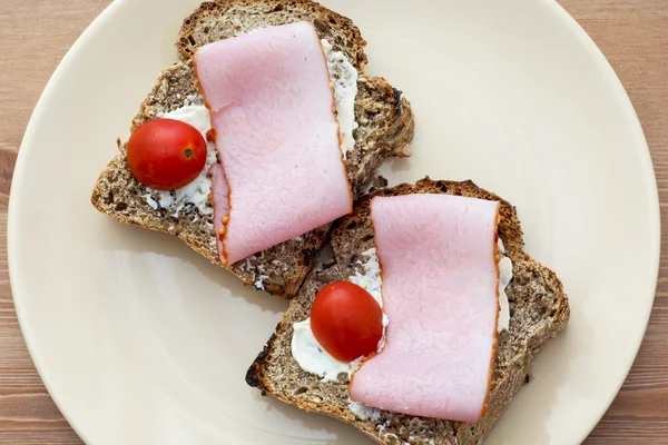 Toasts with butter, ham and cherry tomatoes — Stock Photo, Image