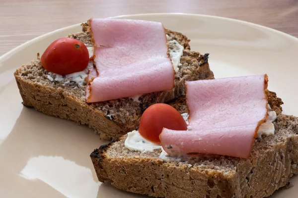 Chutné toasty s máslem, šunkou a cherry rajčaty — Stock fotografie