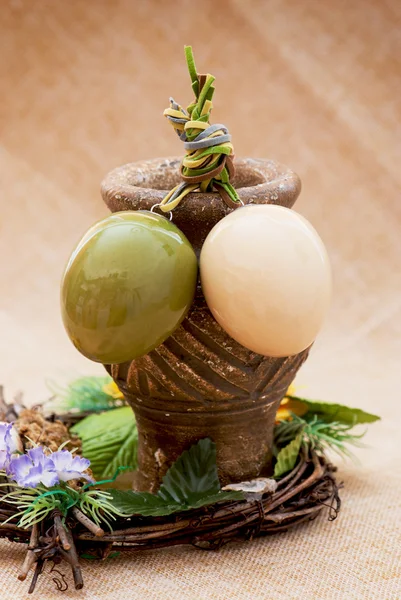 Two shiny easter eggs with ceramic vase and ornamental wicker — Stock Photo, Image