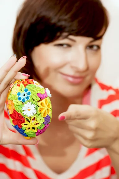 Mladá žena představuje barevné velikonoční vajíčko — Stock fotografie