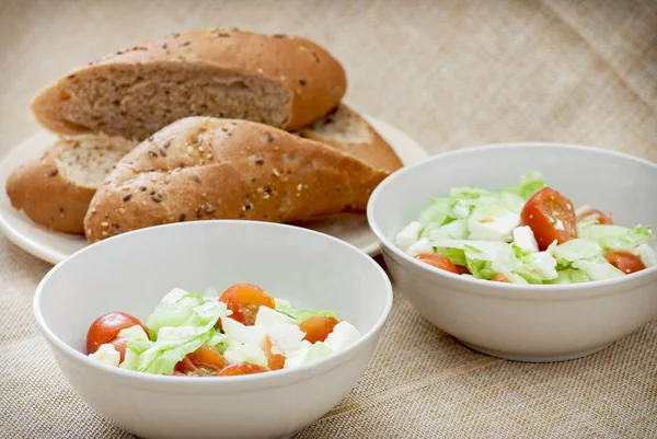 Due porzioni di insalata fetta e fette di pane — Foto Stock