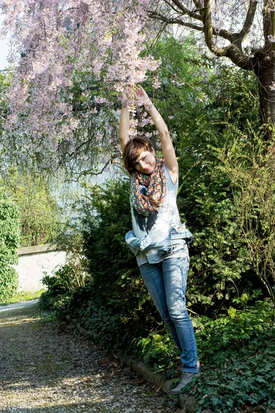 年轻快乐的女人摆下棵开花的树 — 图库照片