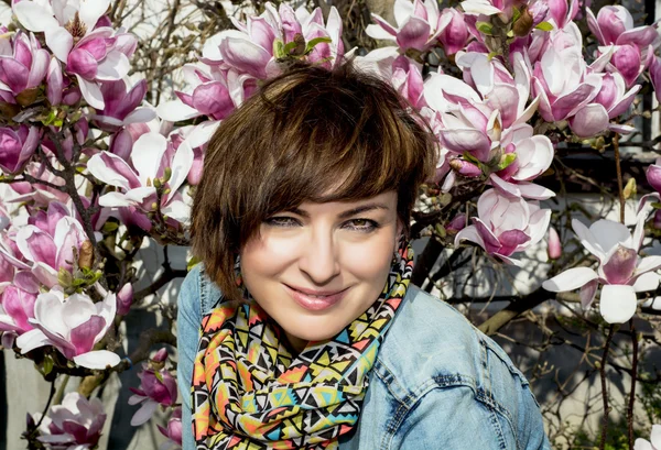 Brunetka kaukaski kobieta i kwitnących magnolii — Zdjęcie stockowe