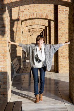 genç kadın yaşlı bir tuğla duvar ile poz