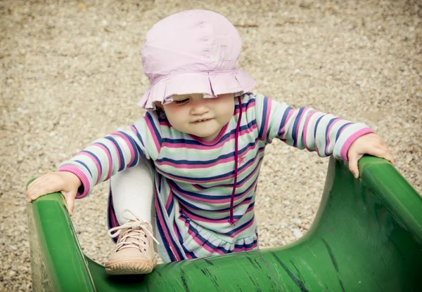 Kleines Mädchen und Spielplatz-Rutsche — Stockfoto