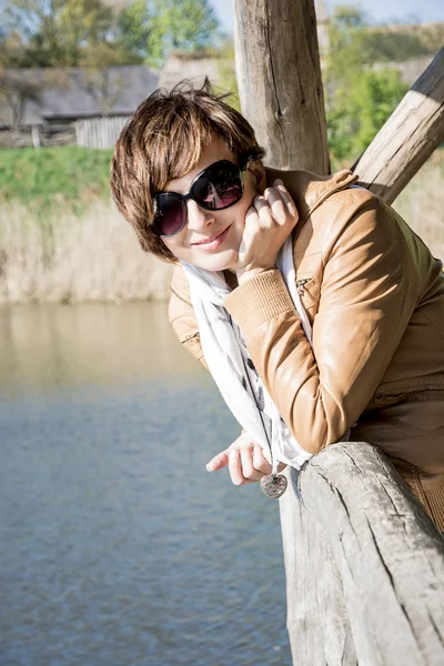 Kavkazský žena na molu u jezera — Stock fotografie